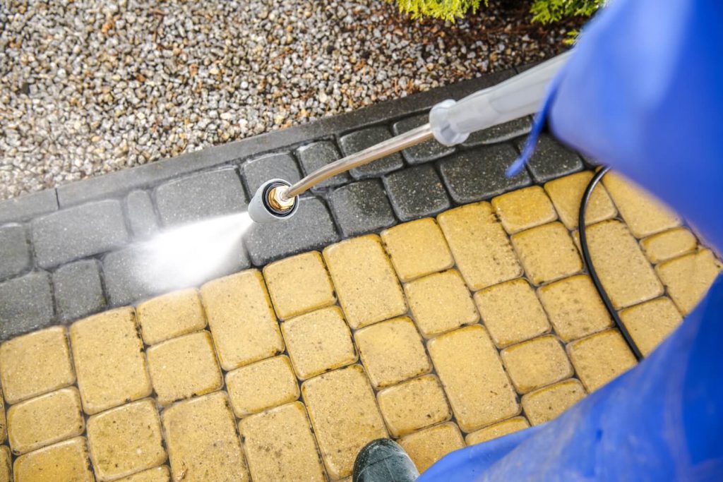 man is cleaning driveway with pressure washing in Melbourne, FL